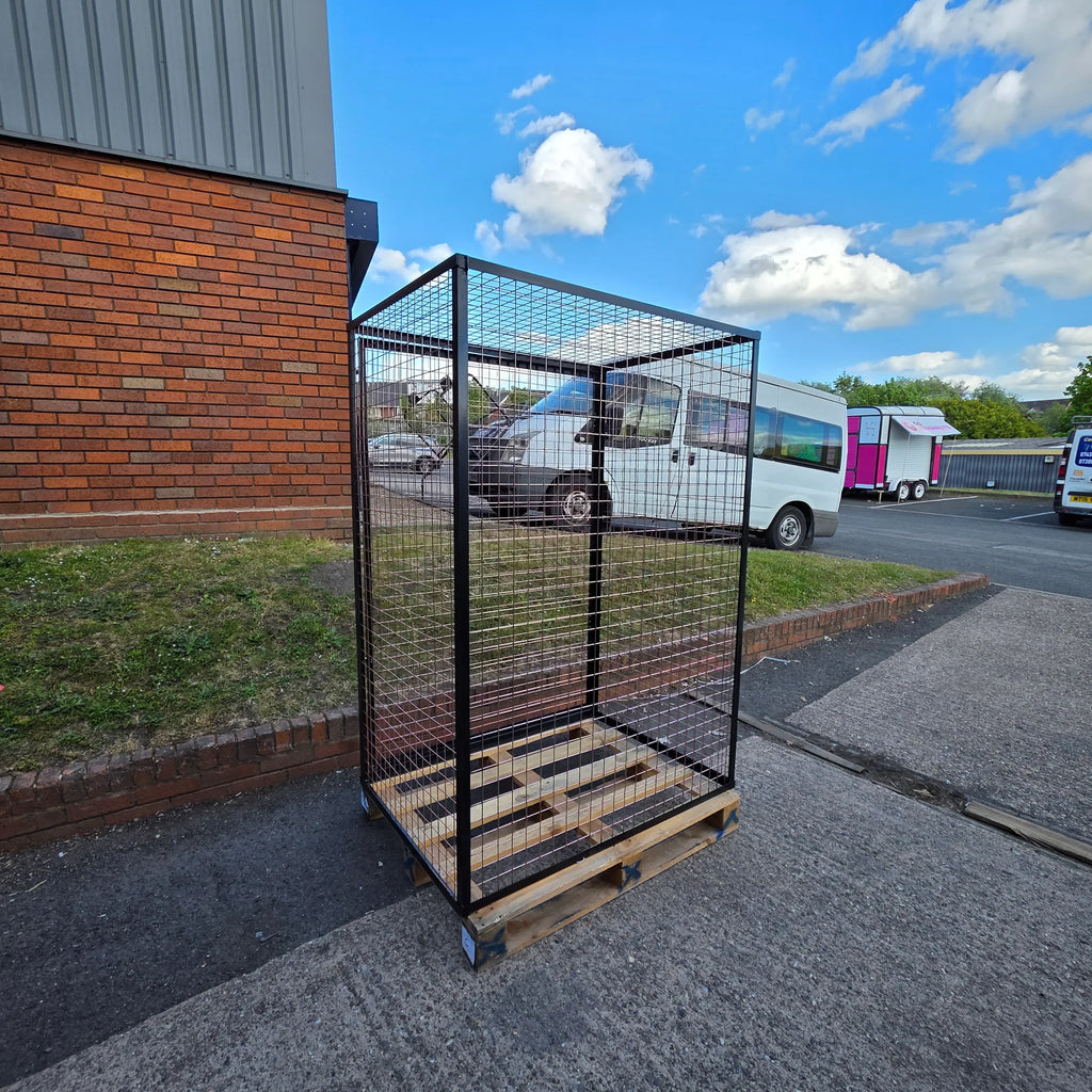 Gas Bottle Cilander Cage Black metal mesh cage on wooden pallet, outdoor industrial storage solution
